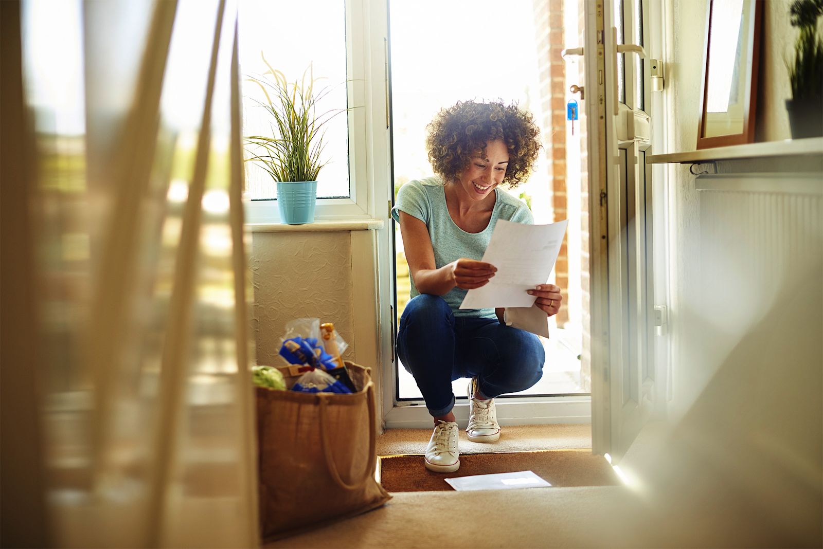 A woman opening an envelope received in the post