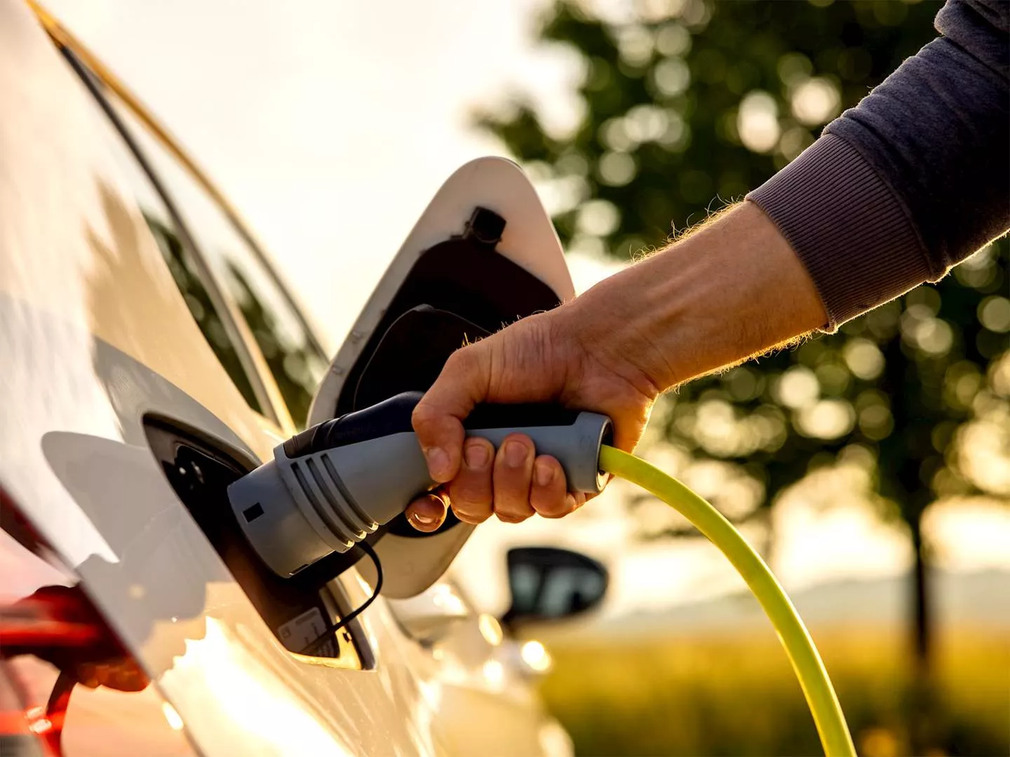 person plugging in their electric car charger
