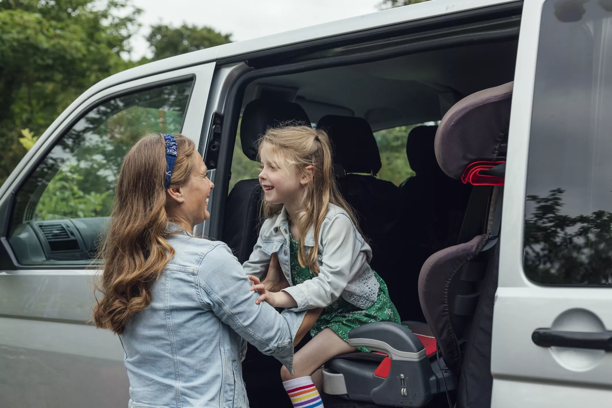 woman helping her child in to their wheelchair accessible vehicle (wav)