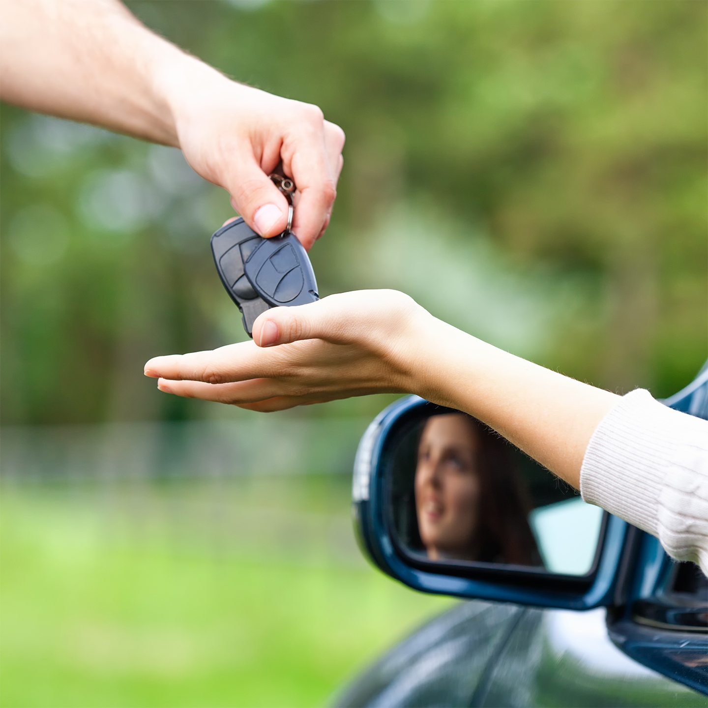A person being handed a set of car keys