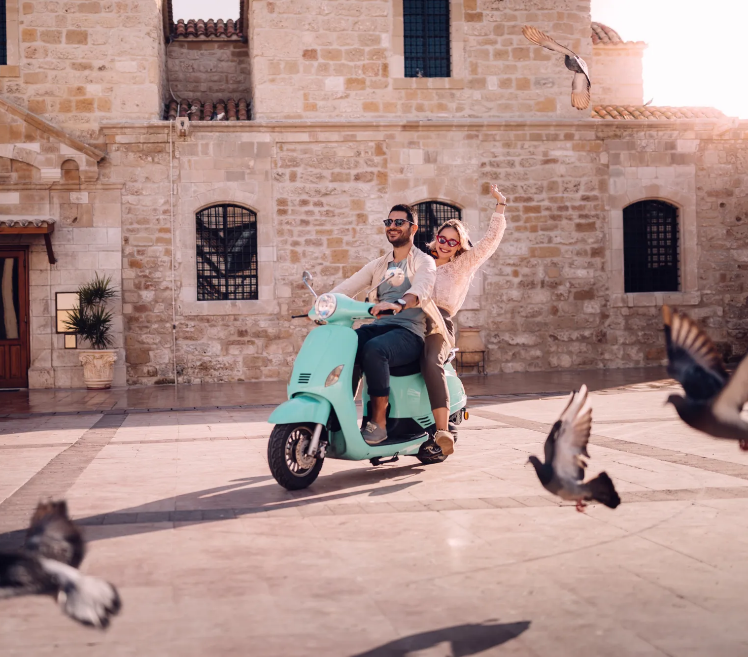 Smiling couple on a scooter in the sun 