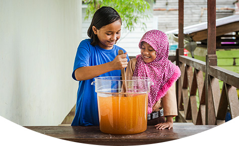 Two children are starting the water purification process and mixing water in a bucket