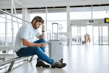 Foto: Ein Mann schaut verzweifelt auf sein Flug-Ticket, er hat sich vertan.