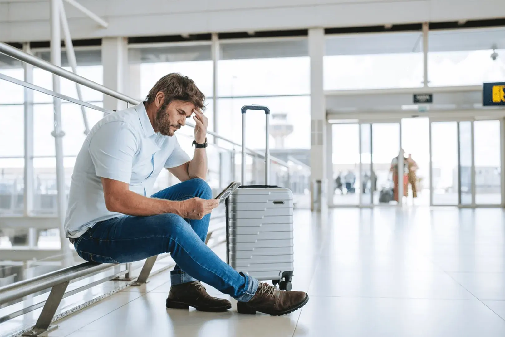 Foto: Ein Mann schaut verzweifelt auf sein Flug-Ticket, er hat sich vertan.