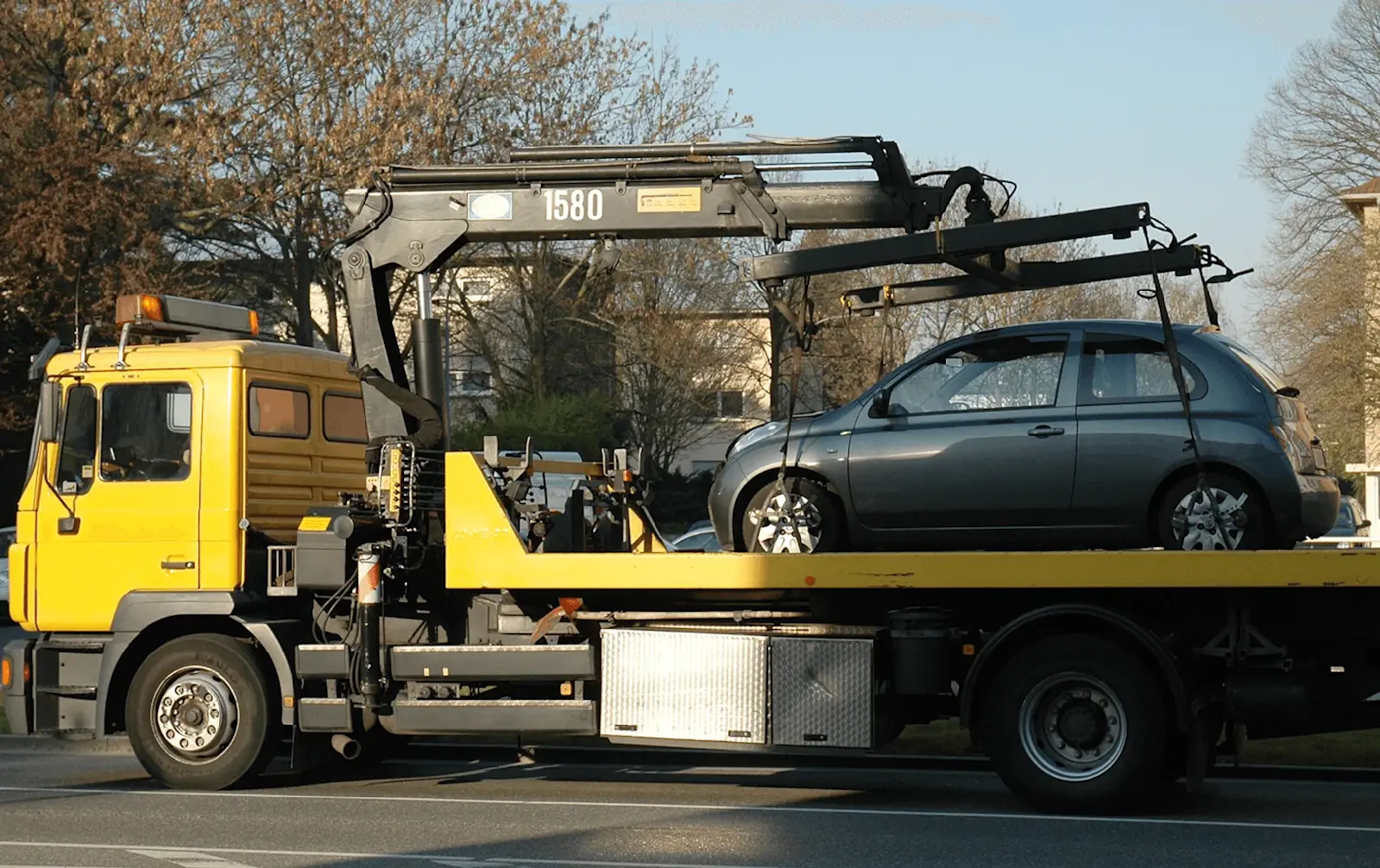 Ein Abschleppwagen hat einen Kleinwagen aufgeladen. 
