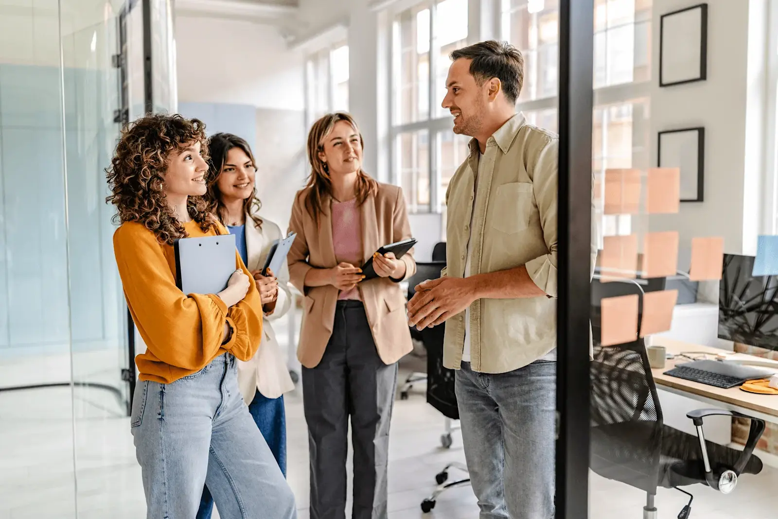 Foto: Arbeitskollegen stehen zusammen und unterhalten sich über ihr Gehalt