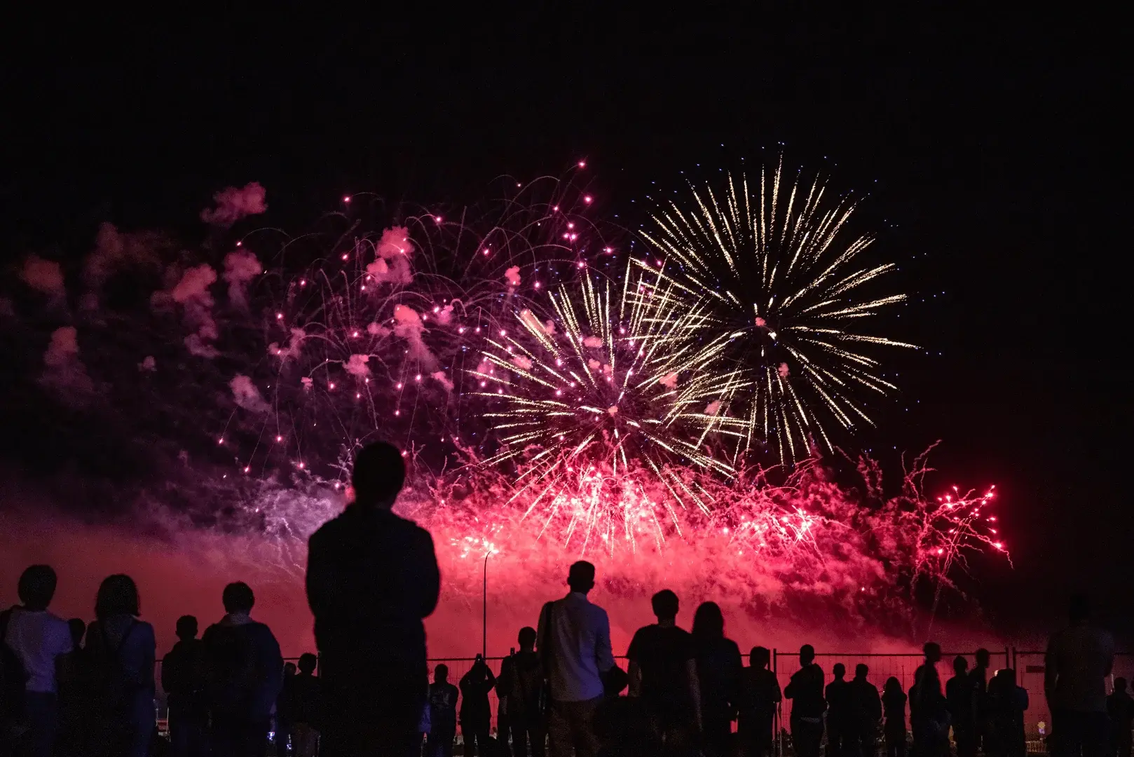 Foto: Eine Gruppe von Menschen schauen sich das Silvester Racketen Spektakel am Himmel an.