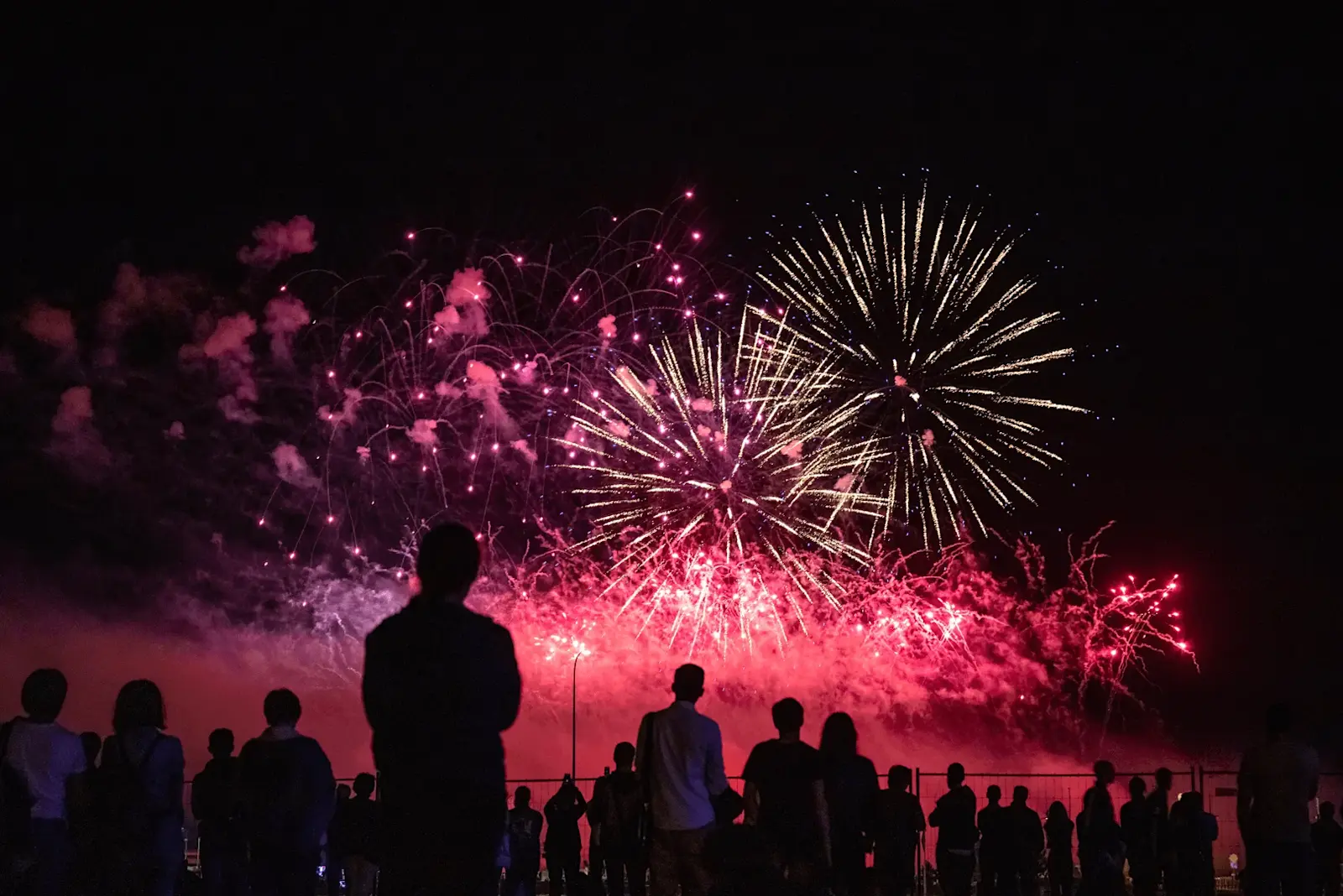 Foto: Eine Gruppe von Menschen schauen sich das Silvester Racketen Spektakel am Himmel an.