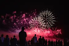 Foto: Eine Gruppe von Menschen schauen sich das Silvester Racketen Spektakel am Himmel an.