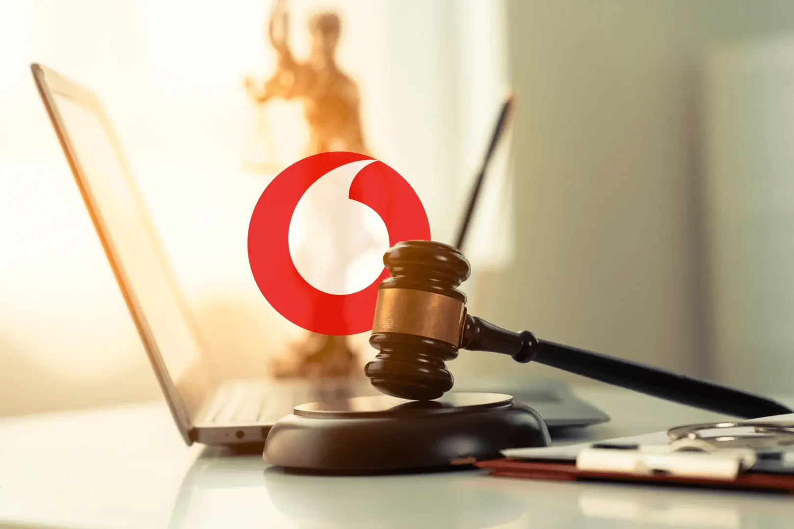 Foto: Das Logo von Vodafone, erscheint hinter einem Richterhammer. im Bezug auf eine Sammmelklage.