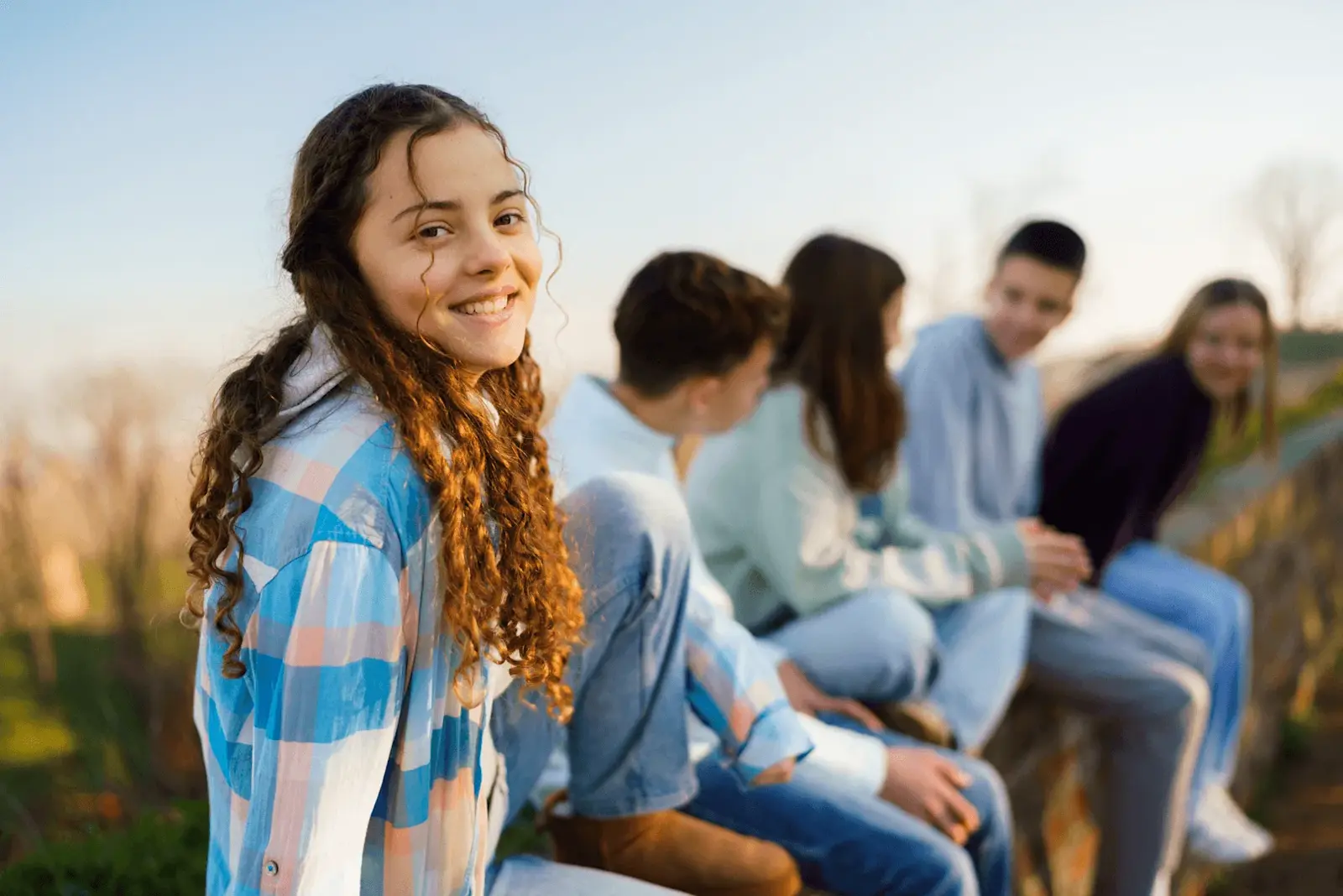 Foto: Teenager sitzen auf einer Mauer
