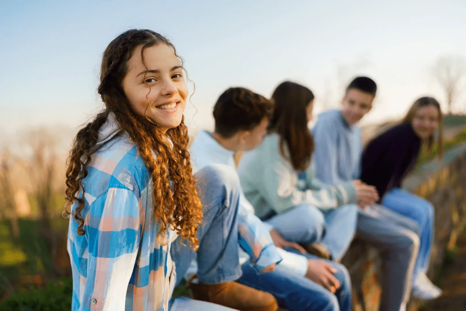 Foto: Teenager sitzen auf einer Mauer