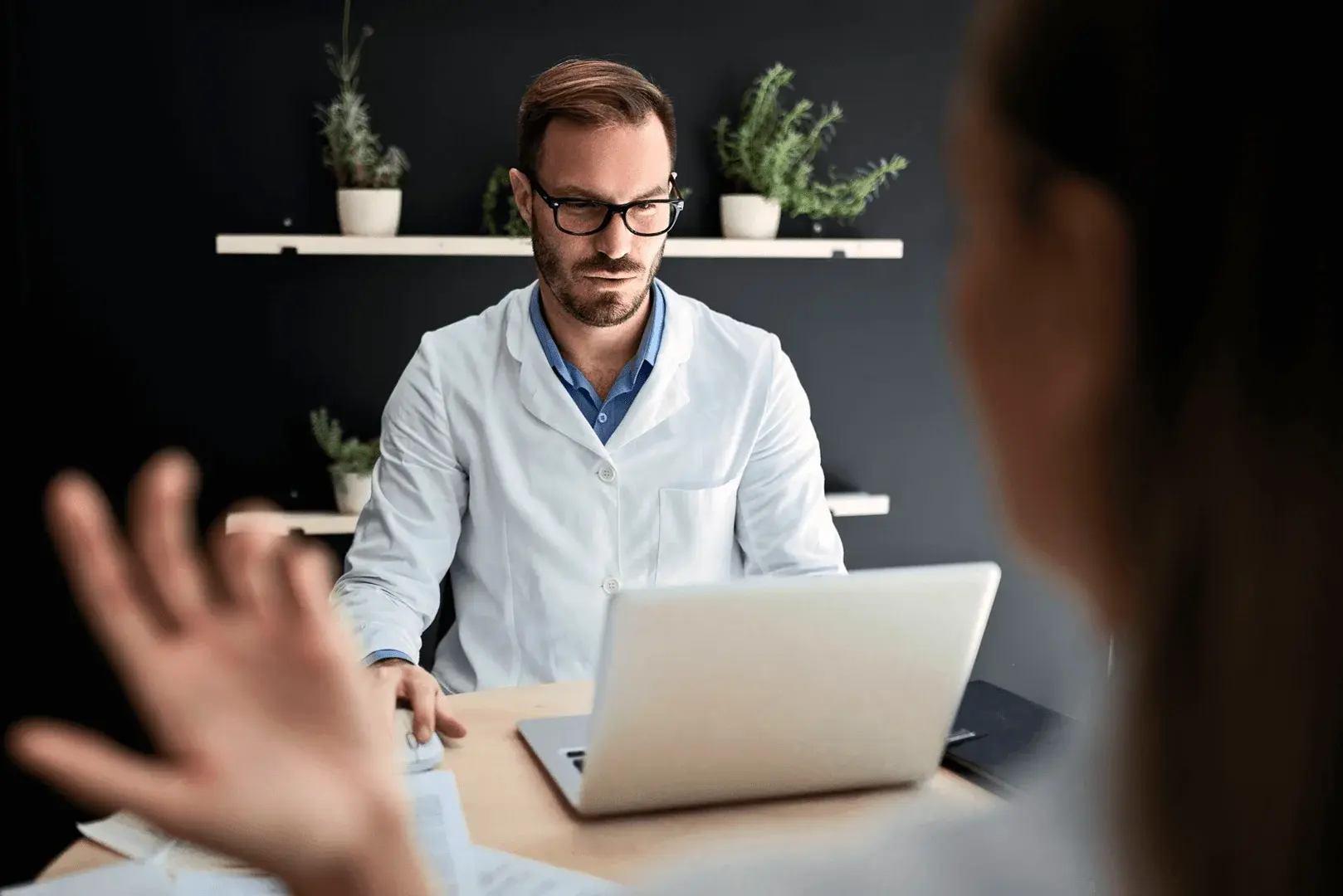 Foto: Eine Frau sitzt vor ihrem Arzt und diskutiert weshalb sie ihre Patientenakte nicht einsehen darf.