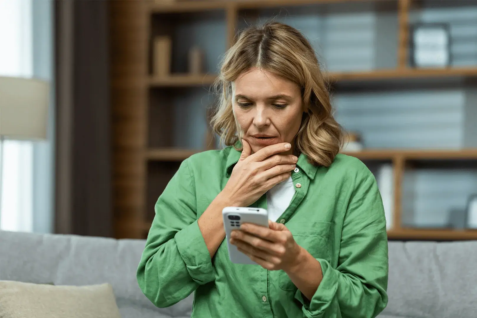 Foto: eine Frau schaut irritiert auf ihr Smartphone.