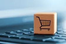 Foto: ein Warenkorb auf einem Würfel steht auf einer Tastatur