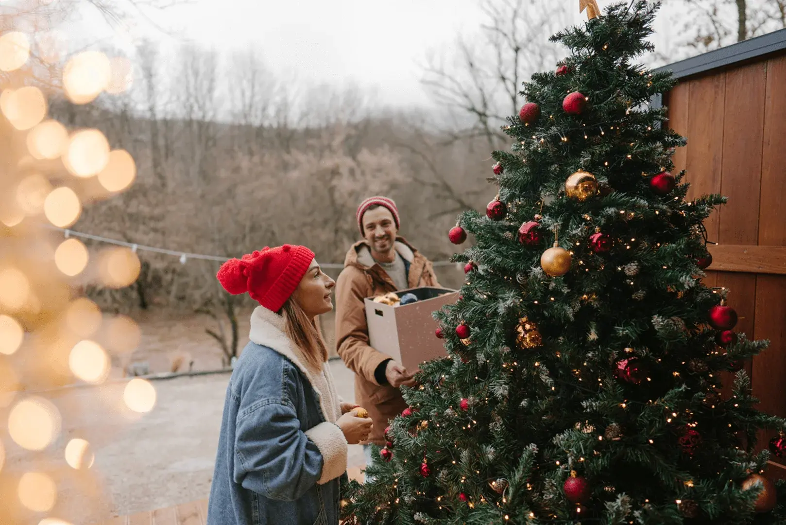 Ein Paar schmückt weihnachtlich den Garten.