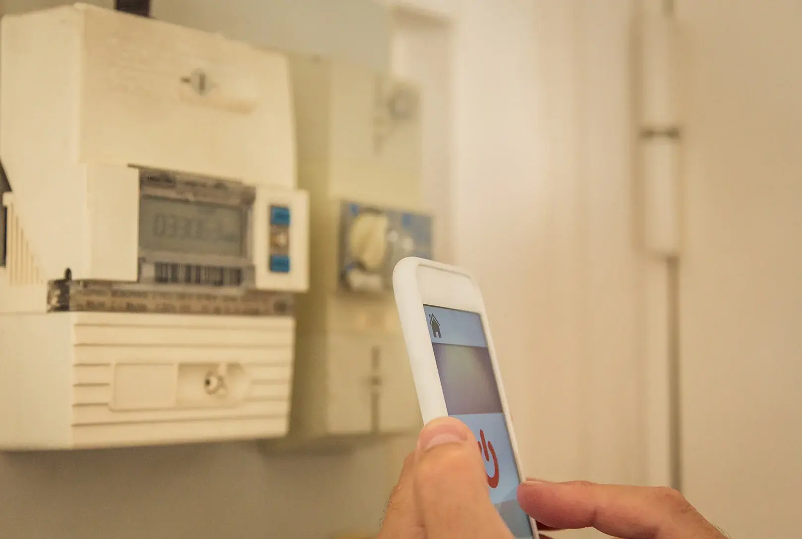 Foto: Ein Stromzähler und ein Smartphone