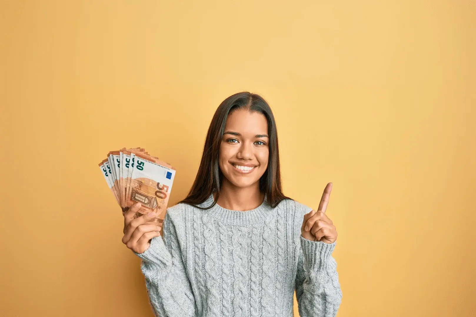 Eine Frau hält Geld in der Hand und lächelt in die Kamera. Die Änderungen 2025. 