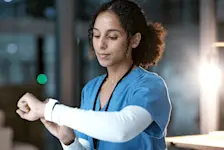 Eine Krankenschwester prüft die Uhrzeit auf ihrer Armbanduhr zur Zeitumstellung. 