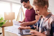 Ein Mann und eine Frau berechnen Nebenkosten der neuen Wohnung zusammen.