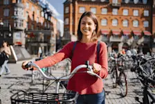 Foto: eine Frau schließt ihr Fahrrad ab