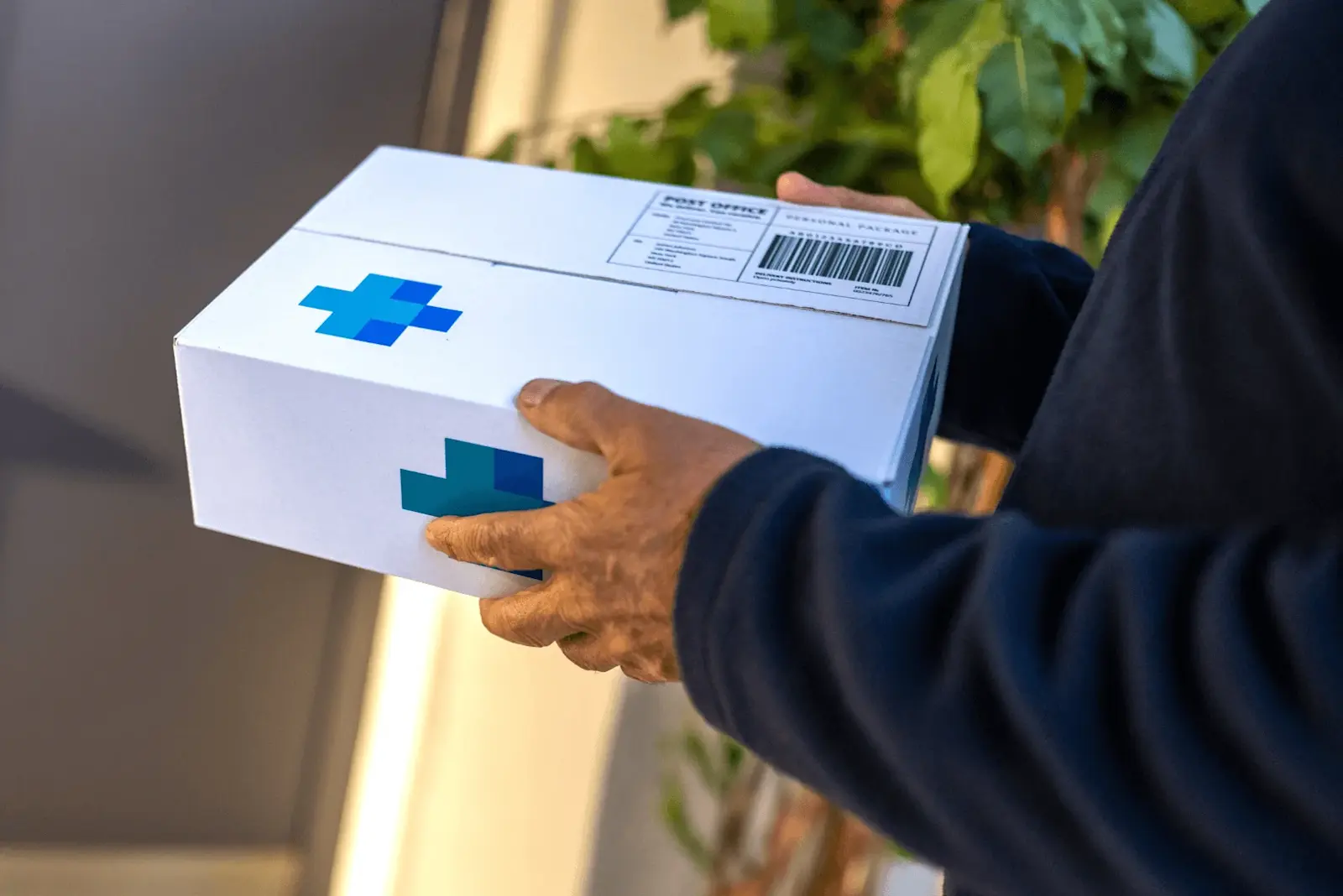 Foto: Ein Paketbote liefert ein Paket von einer Versand-Apotheke