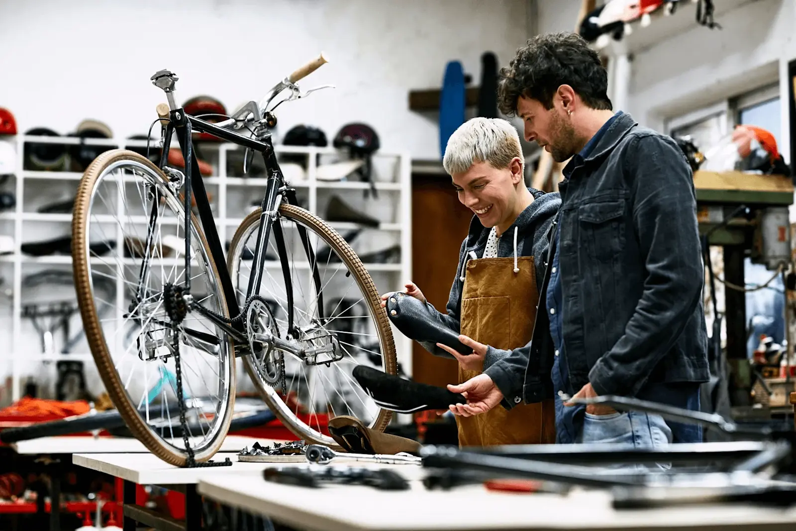Foto: zwei Personen schauen sich ein altes Rennrad an und reparieren es.