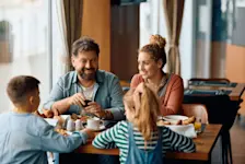 Foto: Familie frühstückt im Hotel und schmiert sich Brote