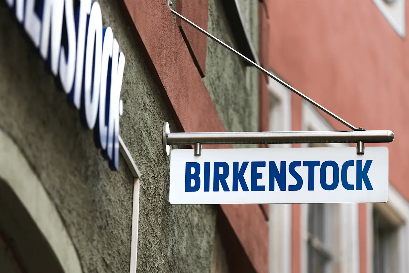 Ein hängendes Schild an einem Gebäude, zeigt das Birkenstock Logo.