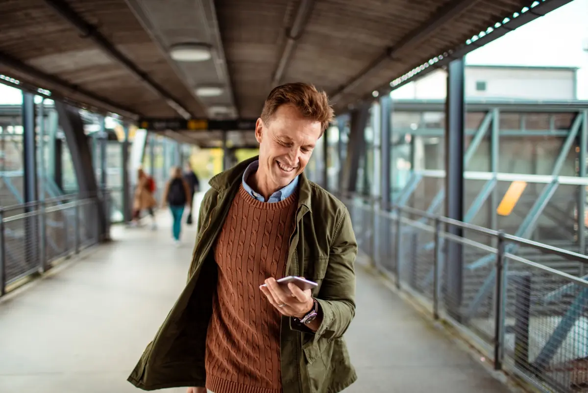 Mann mit Telefon am Bahnhof