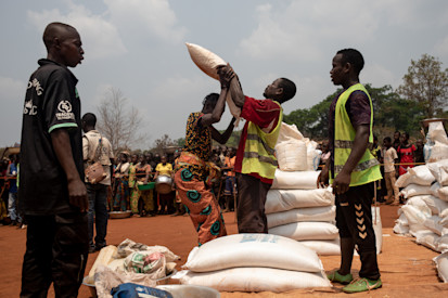 Une femme déplacée se fait donner un sac de nourriture lors d'une distribution de vivres du Programme alimentaire mondial sur le site de déplacés internes de Siwa. ©OCHA/Adrienne Surprenant, Bangassou, Préfecture du Mbomou, RCA, 2021.