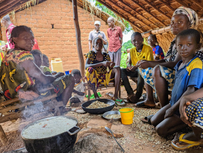 Une famille retournée au village Mourouba prépare un grand pot de riz qu'elle a reçu d'OXFAM dans le cadre d'un projet financé par le Fonds humanitaire pour la RCA afin de lutter contre l'insécurité alimentaire. ©OCHA/A. Cadonau, Mourouba, Préfecture de la Ouaka, République centrafricaine, 2022.