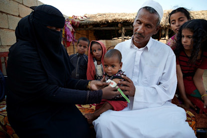 Hamid-Nagmos,-50-years-old,-holds-his-grandchild-as-a-health-worker-takes-his-MUAC Abu-Dahan-village Kassala UNICEF