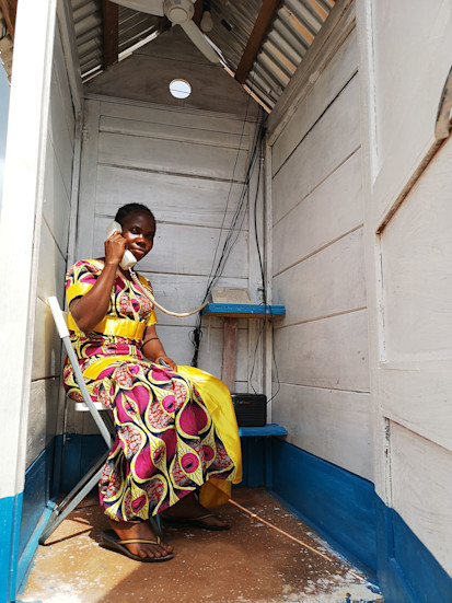 Une femme déplacée utilise l'une des nouvelles cabines téléphoniques du site de personnes déplacées PK3 à Bria pour rester en contact avec sa famille. ©PAM/Elizabeth Millership, Bria, Préfecture de la Haute-Kotto, RCA, 2021.