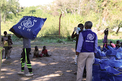 Le personnel de l'OIM distribue des kits d'ANA aux victimes des inondations de Gatumba tout en respectant les mesures de prévention COVID-19. ©Triffin Ntore, OIM Burundi