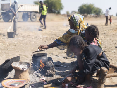 A displaced woman cooks in an open space in the El Ban Gadeed settlement. Photo: OCHA/Ala Kheir