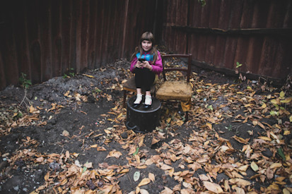 A girl is sitting in her yard close to the “contact line”