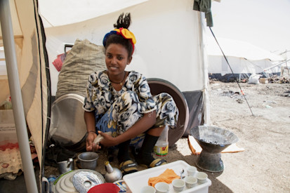 Anna* prepares traditional coffee in the kitchen area of her tent in Tunaydbah refugee settlement, eastern Sudan. © UNHCR/Ahmed Kwarte