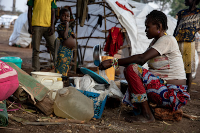 Une famille déplacée par les récentes violences post-électorales est arrivée sur un nouveau site de personnes déplacées à Batangafo et déballe les quelques affaires qu'elle a pu emporter. ©OCHA/Adrienne Surprenant, Batangafo, Préfecture de l'Ouham, RCA, 2021.