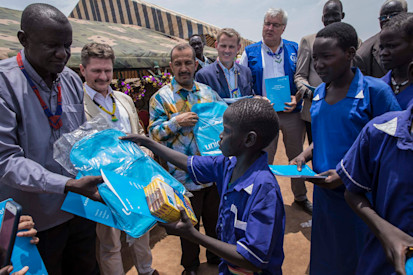 Caption: School children receive school bags, books and other school materials in Aweil town. More than 75,000 children will be reached by the joint programme on education in emergencies. Credit: UNICEF