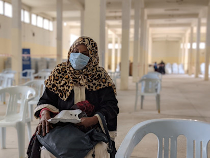 Hawaia waiting to receive her parcel during a UNHCR/WFP food distribution (OCHA/Jennifer Bose Ratka)