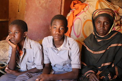 Montaser, 14, inside his home in Khartoum, Sudan with his brother Moayad, 12 and his mother Ihasan, 42