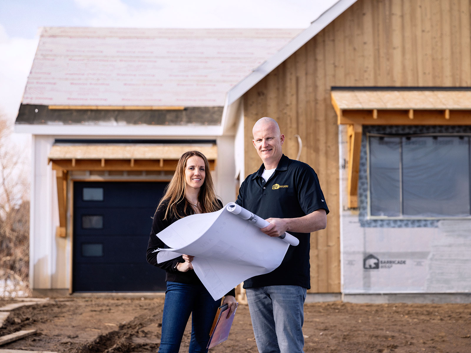 Man and woman looking at plans on a construction-Site