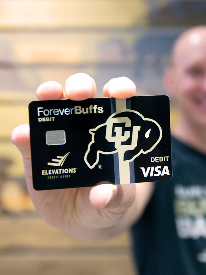 Man holding a Forever Buffs Debit card