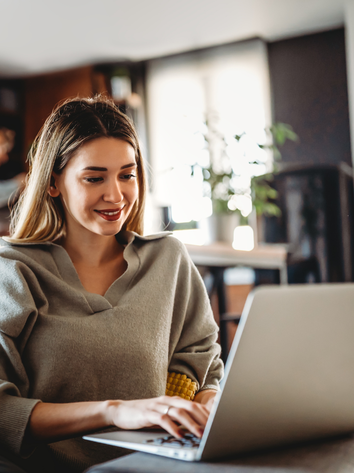 Young female sitting at a table typing on a computer