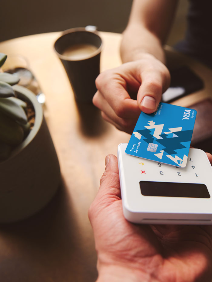 Una persona que paga un café con una tarjeta de crédito con un lector de tarjetas móvil