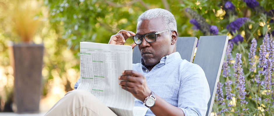 Man reading a business newspaper outdoors