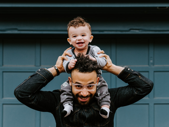 A father holds his young son on his shoulders