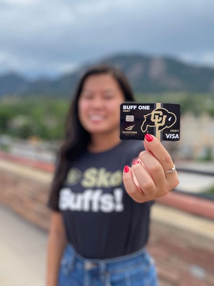 Woman holding a Buff One card on the University of Colorado campus
