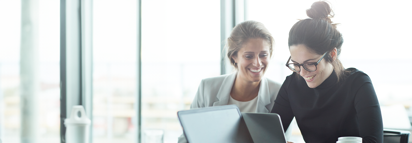 Dos compañeras de trabajo colaborando en un espacio de oficina